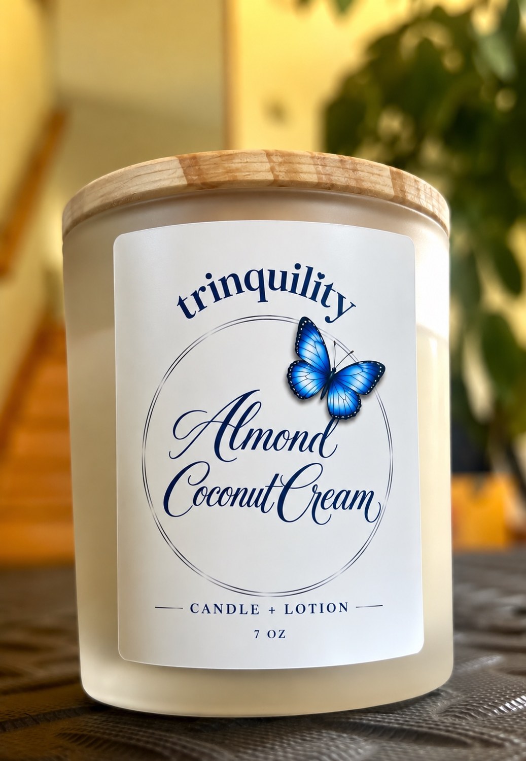 Trinquility Almond Coconut Cream massage candle with wooden lid and blue butterfly label